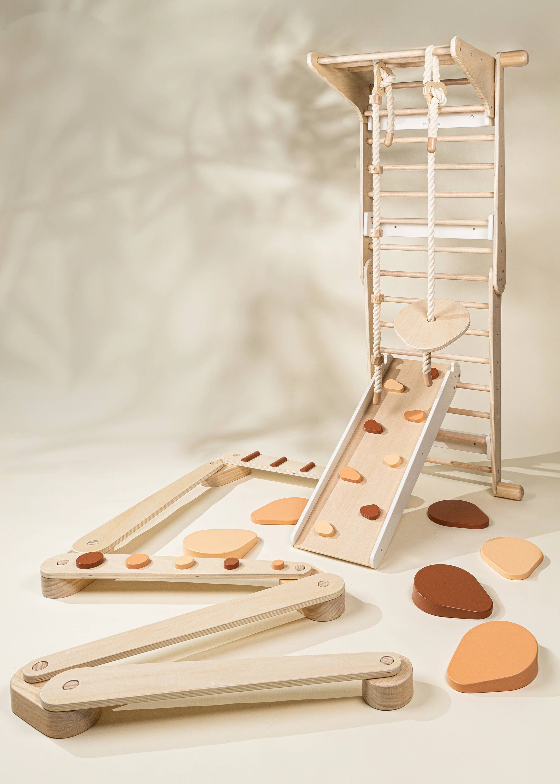 Wooden toy set with ramps and stones on a neutral background