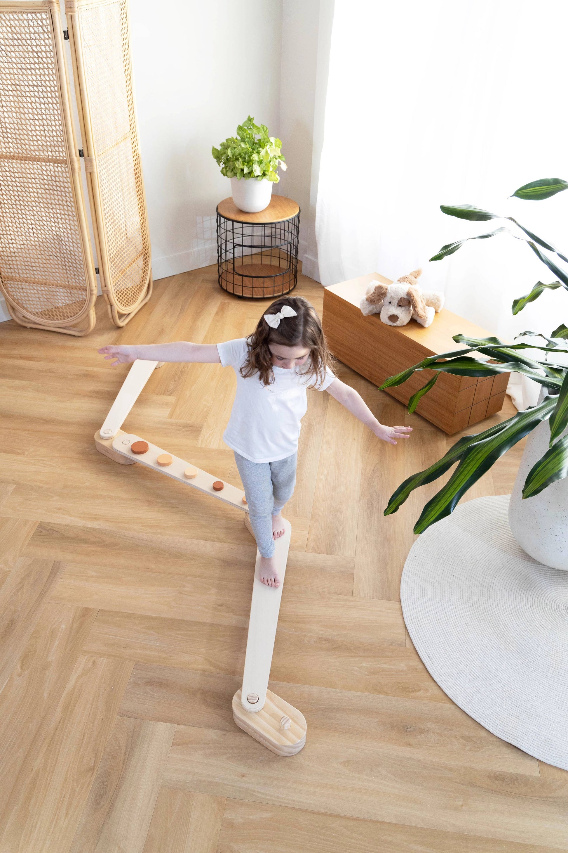 Child playing with a wooden balance board in a home setting
