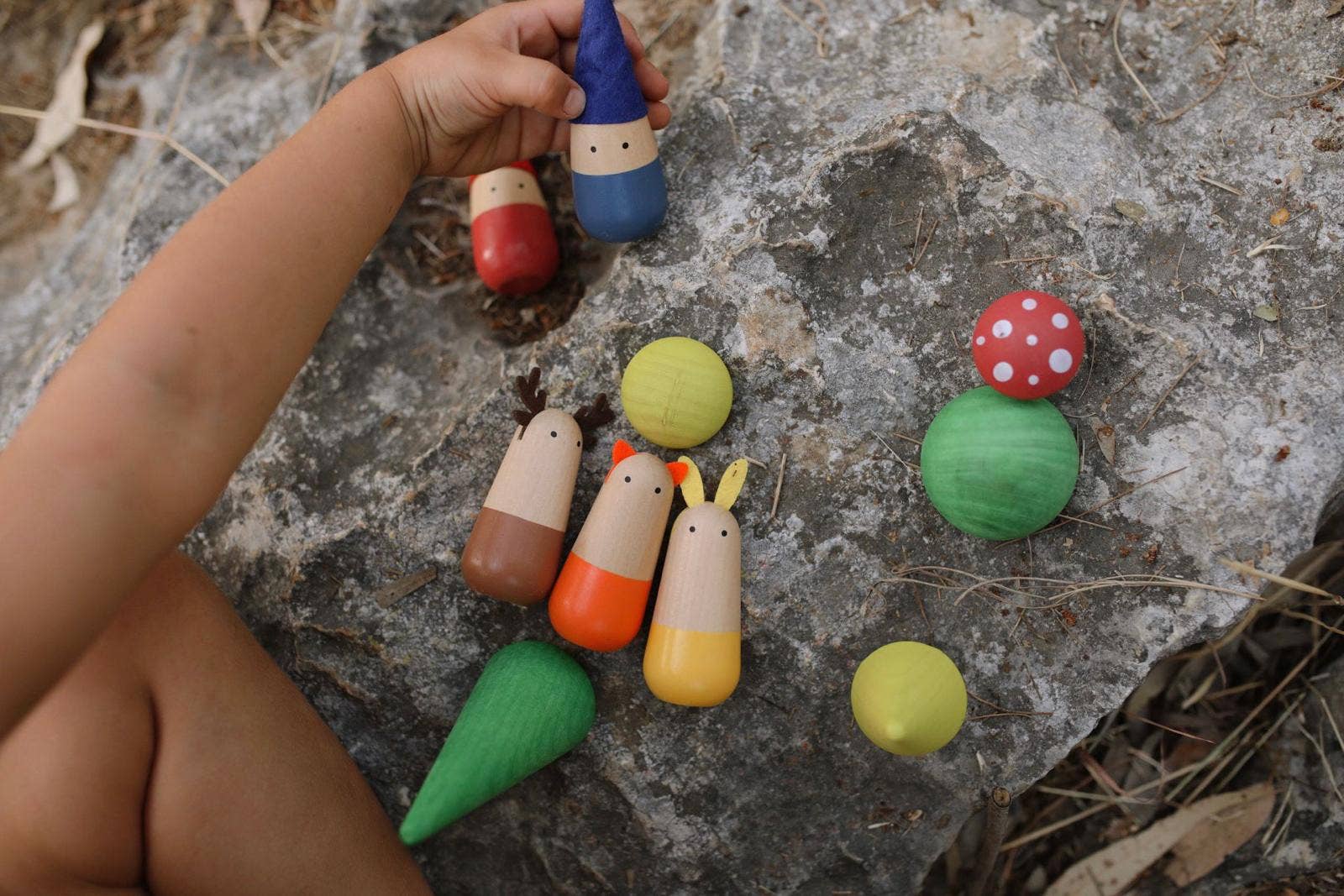 Colorful wooden imaginative play toys on a stone surface