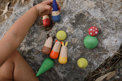 Colorful wooden imaginative play toys on a stone surface