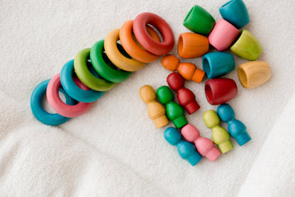 Colorful wooden baby toys on a white surface