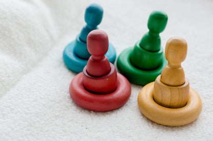 Four colorful wooden toys on a textured surface