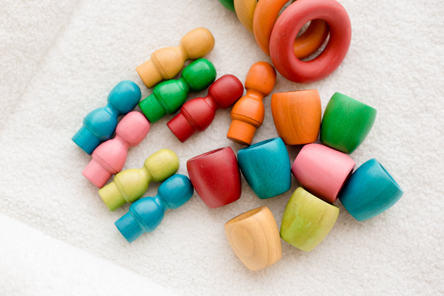 Colorful wooden baby toys on a white surface